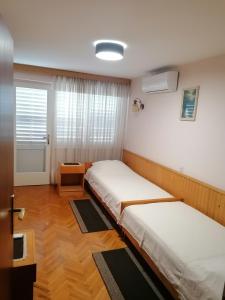 una camera con due letti e una finestra di Guesthouse Butković a Punat