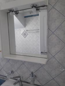 espejo sobre un lavabo en el baño en Lefakis Aegean Breeze Apartment, en Órmos