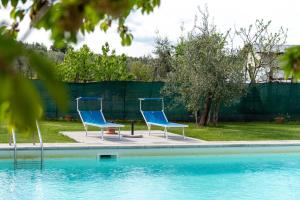 twee blauwe stoelen naast een zwembad bij Mugellese in Civitella in Val di Chiana