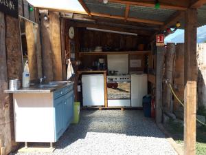 eine Außenküche mit einer Spüle und einem Kühlschrank in der Unterkunft Maurienne Outdoor - Nuit insolite en Yourte en Savoie in Saint-Georges-des-Hurtières