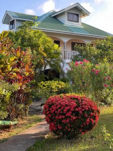 a house with a bunch of flowers in front of it at Linsen Selfcatering Apartments in La Digue