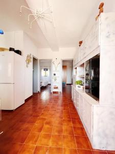 a kitchen with white cabinets and a red tile floor at Villa galana in Les Cases d'Alcanar +18 photos