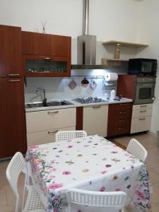 een keuken met een tafel en twee stoelen en een tafel en een keuken met bij casa vacanza con balcone in Laterza