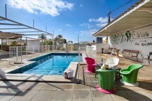 una piscina con sillas coloridas junto a un edificio en Casa Rural Jovial en Ingenio