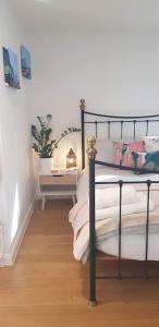 um quarto com uma cama preta e piso em madeira em Lauriston Stay em Birch