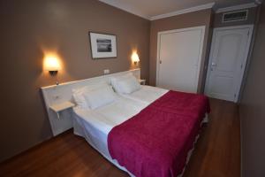 a bedroom with a large bed with a red blanket at Coral La Quinta Park Suites in Santa Úrsula
