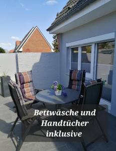 eine Terrasse mit 2 Stühlen und einem Tisch in der Unterkunft Bude im Windrosenweg in Cuxhaven