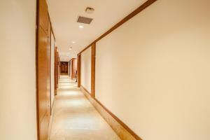 a long hallway with white walls and wooden floors at FabHotel Hexa Chhatarpur in New Delhi