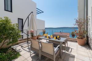 patio con mesa y sillas en el balcón en Apartments Liam, en Trogir
