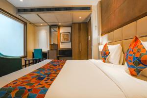 a hotel room with a large bed and a chair at FabHotel Hexa Chhatarpur in New Delhi