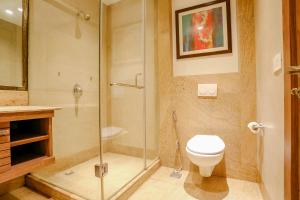 a bathroom with a toilet and a glass shower at FabHotel Hexa Chhatarpur in New Delhi
