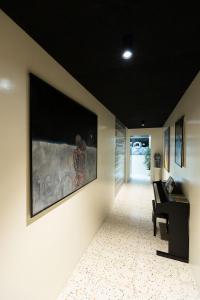 un corridoio con pianoforte e un grande dipinto sul muro di Pepper Lounge & Suite a Bolzano