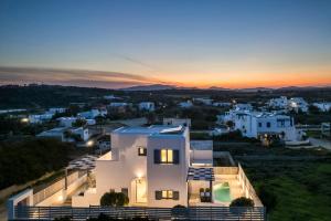 a villa with a view of a city at sunset at Pebble Summer House in Kampos Paros