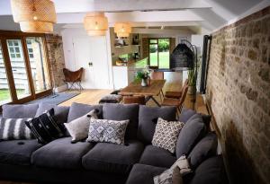 a living room with a blue couch with pillows at The Barn House - Swimming Pond,Jacuzzi,Chicks! in Battle