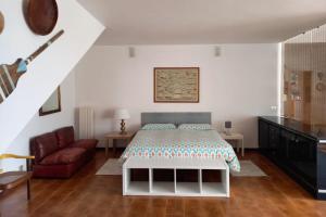 Villa ai Sugheri في ديفا مارينا: غرفة نوم بسرير واريكة