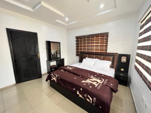 a bedroom with a bed and a black door at CampDavid Luxury Apartments Ajao Estate Airport Road Lagos 0 8 1 4 0 0 1 3 1 2 5 in Lagos