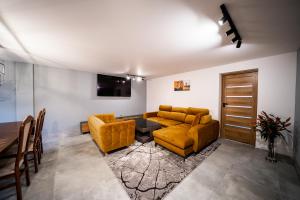 ein Wohnzimmer mit einem Sofa, einem Tisch und Stühlen in der Unterkunft Apartament P&B in Rybnik