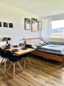 1 dormitorio con cama, mesa, mesa y sillas en Wolfgangsee Seeblickplatzl 119 en Strobl