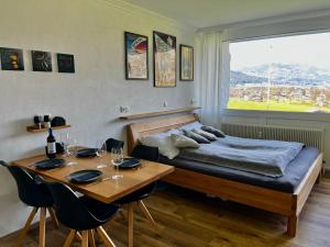 1 dormitorio con cama, mesa, mesa y sillas en Wolfgangsee Seeblickplatzl 119 en Strobl