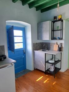 a kitchen with a blue door and a sink at LA-REEF at Lakki, Leros in Lakkíon