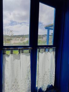 two windows with white curtains in a blue room at LA-REEF at Lakki, Leros in Lakkíon