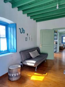 ein Wohnzimmer mit einem Sofa und Holzboden in der Unterkunft LA-REEF at Lakki, Leros in Lakkíon