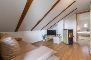 ein Wohnzimmer mit einem Sofa und einem TV in der Unterkunft SOKOL - Secret forest house in Gračac
