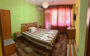 a bedroom with a bed in a room with green walls at ALPHA family HOTEL in Blagoevgrad