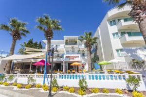 un hôtel avec une piscine et des palmiers dans l'établissement Bodrum Moonlight Otel, à Turgutreis