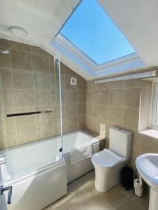a bathroom with a toilet and a sink and a skylight at Home From Home - Sleeps 8 in Portland