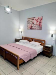 a bedroom with a bed and a painting of pink roses at spiros maria studios in Corfu Town