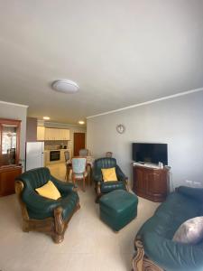 een woonkamer met een bank en stoelen en een keuken bij Saranda relax apartments in Sarandë