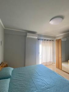 een slaapkamer met een blauw bed en een raam bij Saranda relax apartments in Sarandë