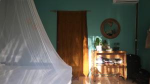 a bedroom with a bed with a white mosquito net at UTOPIA in Gili Air