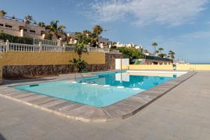 basen z niebieską wodą przed plażą w obiekcie Lightbooking playa de Amadores La Concha w mieście Puerto Rico de Gran Canaria