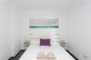sypialnia z białym łóżkiem i fioletową poduszką w obiekcie Lightbooking playa de Amadores La Concha w mieście Puerto Rico de Gran Canaria +37 zdjęć