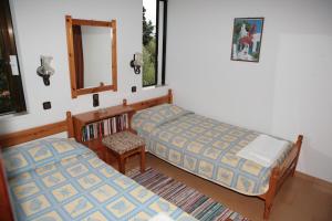 a bedroom with two beds and a mirror and a chair at Villas Michalis in Chorafakia +37 photos