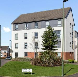 un gran edificio blanco con un cartel delante en Ferry Gait en Edimburgo