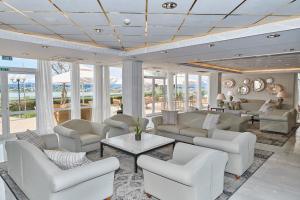 a living room with white furniture and windows at Divani Corfu Palace in Corfu