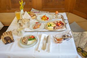 une table blanche avec des assiettes de nourriture dans l'établissement Weisses Rössl, à Caldaro
