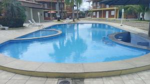 una gran piscina con agua azul en un patio en Chalé Aconchego en Barreirinhas