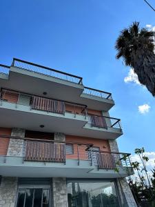 un alto edificio con balconi e una palma di EVa's Luxury Apartments No 4 a Artemida