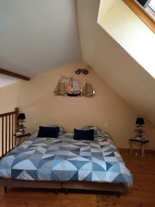 ein Schlafzimmer mit einem blauen und weißen Bett im Dachgeschoss in der Unterkunft Gîte berneval le grand in Berneval-le-Grand