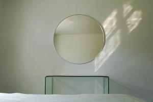 un espejo colgado en una pared junto a una cama en RIVA BELLA villa plage, en Bandol