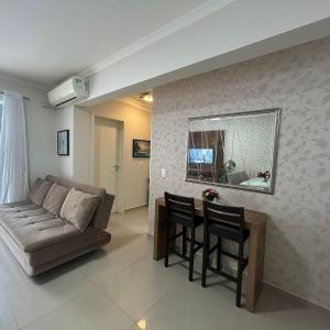 uma sala de estar com um sofá e uma mesa em 037C - Apartamento 2 dormitórios na praia de Bombas em Bombinhas