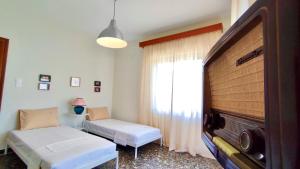 a room with two beds and a large window at Carpenter's House in Skala Sotiros