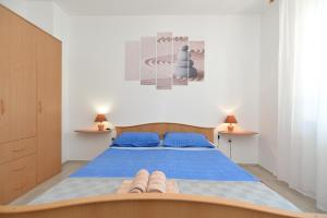1 dormitorio con cama azul y almohadas azules en Apartments Lavanda 108, en Fažana