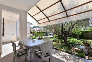 comedor con mesa y sillas en el patio en Apartments Lavanda 108, en Fažana