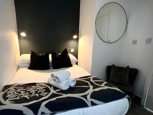 ein Schlafzimmer mit einem Bett mit zwei Handtüchern darauf in der Unterkunft The Courtyard, Manstone House in Kent