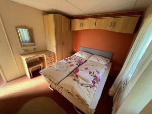 een kleine slaapkamer met een bed en een spiegel bij Penzión Tulip in Červený Kláštor